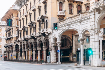 Fototapeta premium Genoa, Italy - September 22, 2024: Elegant arcaded facades and ornate historic buildings line Via XX Settembre, the city’s main shopping street.