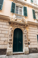 Genoa, Italy - September 22, 2024: Ornate historic doorway with sculpted figures and baroque stucco decor on a palazzo facade in the UNESCO-listed city center.