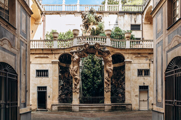 Genoa, Italy - September 22, 2024: Baroque courtyard with monumental atlantes and lush grotto in Palazzo Nicolosio Lomellino, a UNESCO World Heritage palace on Via Garibaldi.