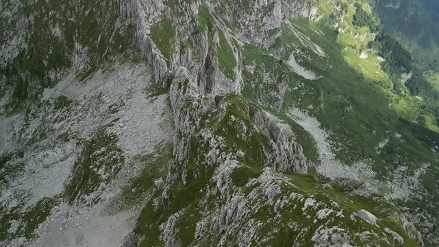 rocky mountains covered with green moss in expansive misty valley in Levico Terme, Italy