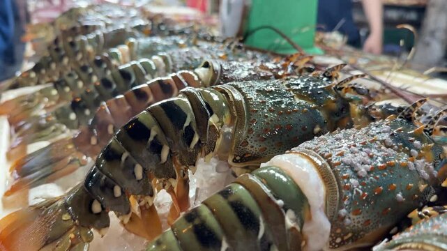 Fresh seafood on ice with crabs, fish, lobster, and green peppers displayed at a market