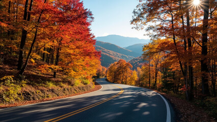 Naklejka premium Scenic winding road through vibrant autumn forest with colorful trees and mountains