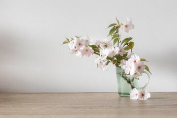 spring flowers in glass cup on wooden table