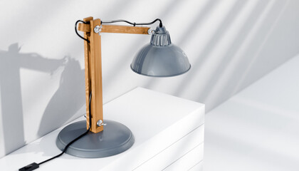 Retro or vintage style desk lamp, classic wooden arm with metal base and grey colored canopy,...