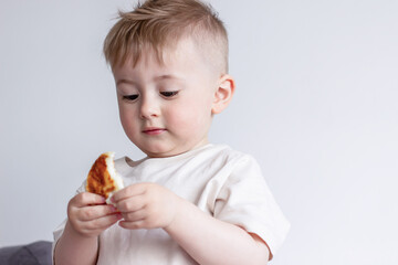 A piece of bitten pancake in a child's hands, a child eats pancakes