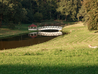 Landscape with a white arched bridge and a gazebo in the forest, lake, greenery, relax, beautiful,...