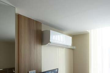 Air conditioner on wall indoor unit. Include light from window, curtain. Part of air conditioning HVAC split system for climate, temperature and humidity control. To cool in room of home building.