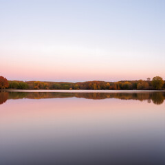Obraz premium Sunset Reflections Over Calm Lake