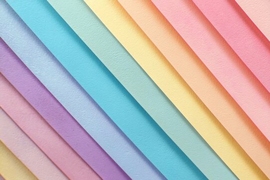 Colorful pastel rainbow-colored paper background with diagonal stripes of different colors, soft
