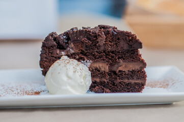 Slice of layered chocolate cake served with vanilla ice cream — decadent dessert on a plate
