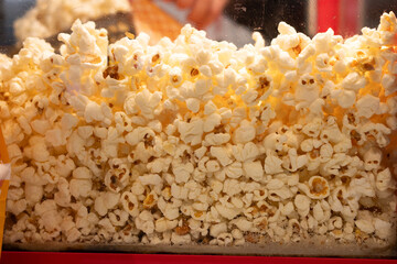 Popcorn is freshly cooked and stored in a glass for display as street food, ready for packing