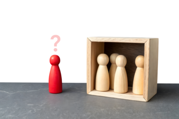 A minimalistic scene with five wooden figurines. Four natural wood-colored figurines stand in a row inside a dashed rectangular box