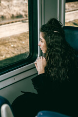 A girl on a train looks out the window