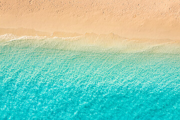 Naklejka na ściany i meble Beautiful bright sea with waves splashing on beach sandy shore. Summer seascape beautiful waves blue sea water in sunny day. Top view from drone. Scenic aerial view amazing tropical nature background
