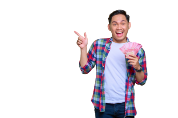 Amazed young Asian man in plaid shirt holding money banknotes and pointing fingers aside at copy space isolated on transparent background