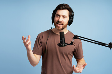 Content creator recording a podcast wearing headphones and speaking into microphone