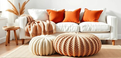 Cozy knitted pouf accents a white sofa styled with a blanket & terracotta pillows in a Scandinavian hygge living room,  wool,  home decor