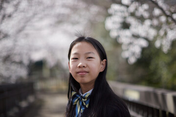 春の桜満開の公園で遊ぶ元気な女子中学生の姿