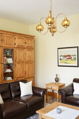 Fototapeta premium elegant living room with brown leather sofa and wooden cabinet