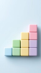 Obraz premium Pastel-colored blocks are stacked in a staircase pattern against a light blue background.