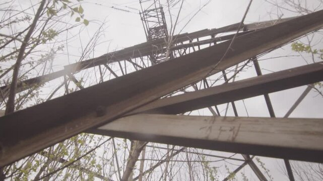 Wide angle shot of high voltage tower in summer rain. Bottom up. Camera moves forward.