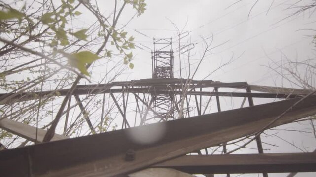 Wide angle shot of high voltage tower in summer rain. Bottom up.