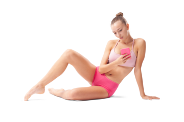 Young woman training in artistic gymnastics, a rhythmic gymnast taking a break and using her phone. Sports workout, fitness, and well-being concept, isolated on white background