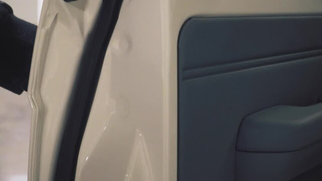 Close-up of a man's hand pulling the handle and opening the door of an SUV.