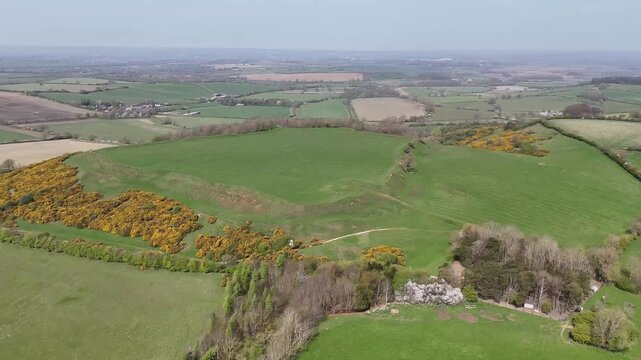 An aerial view rotating at a distance from the remains of the Iron Age Hillfort in rural Leicestershire, UK in springtime