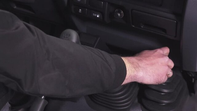 Close-up of a man's hand pressing Front wheel drive control lever in a car.