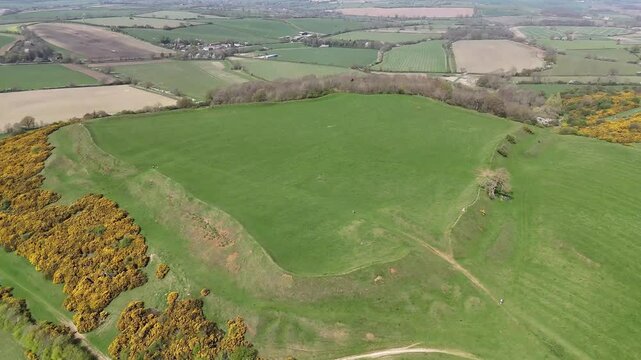 An aerial view vertical pan above the remains of the Iron Age Hillfort in rural Leicestershire, UK in springtime