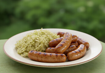 Fototapeta premium Grilled Sausages with Sauerkraut on a White Plate