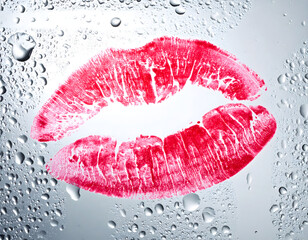 A red lipstick kiss mark imprinted on wet glass.