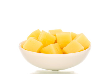 Fragrant hard cheese cut into cubes in a white ceramic plate isolated on a white background, macro.