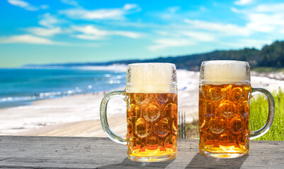 Two glasses of fresh beer on the beach
