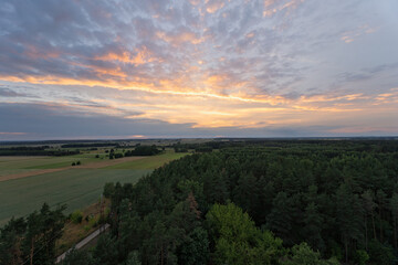 A beautiful sunset over a forest with a road in the background