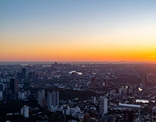 Obraz premium Stunning sunset cityscape panorama. Golden hour light bathes urban sprawl.