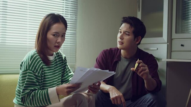 Financial strain testing relationship stability, married couple experiencing intense emotional conflict while examining unpaid bills and credit card statement