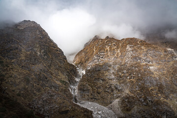 Beautiful Himalayan Glacial Waterfalls in the Mountains with a Bridge in the Langtang Region of Nepal.