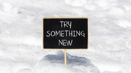 Try something new symbol. Concept words Try something new on beautiful blackboard. Beautiful white snow background. Business motivational lifestyle try something new concept. Copy space.