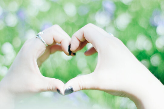Close-up of a Woman wearing nail polish making a heart shape with her hands