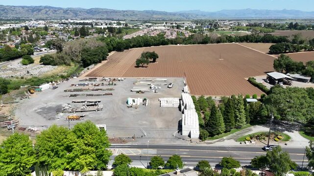 Drone urban view of Gilroy and Monterey Street area with construction site, fields and greenery