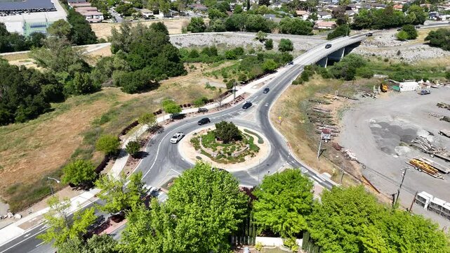 Drone view of roundabout with traffic in Gilroy and Monterey Street area surrounded by greenery