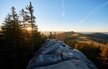 Scenic sunrise at Pysanyi Kamin in Carpathians, Ukraine. Rocky surface in foreground. Breathtaking...