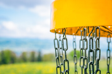 yellow disc golf basket with blurred background