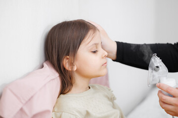 child is sick in bed. inhalation at home. Mom gives medicine to her daughter. Concept disease,...