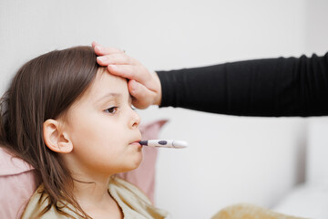 child is sick in bed. little girl measures body temperature. Concept disease, pharmaceutics.
