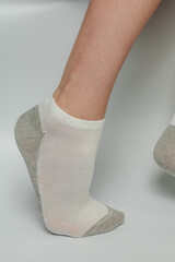Female legs in socks on a gray background. Close-up.