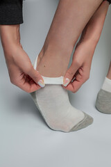 Female legs in socks on a gray background. Close-up.