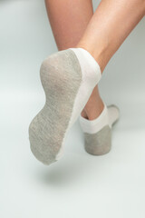 Female legs in socks on a gray background. Close-up.